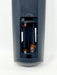 Close-up of the back of a dark blue remote control showing the battery compartment with two batteries inserted.