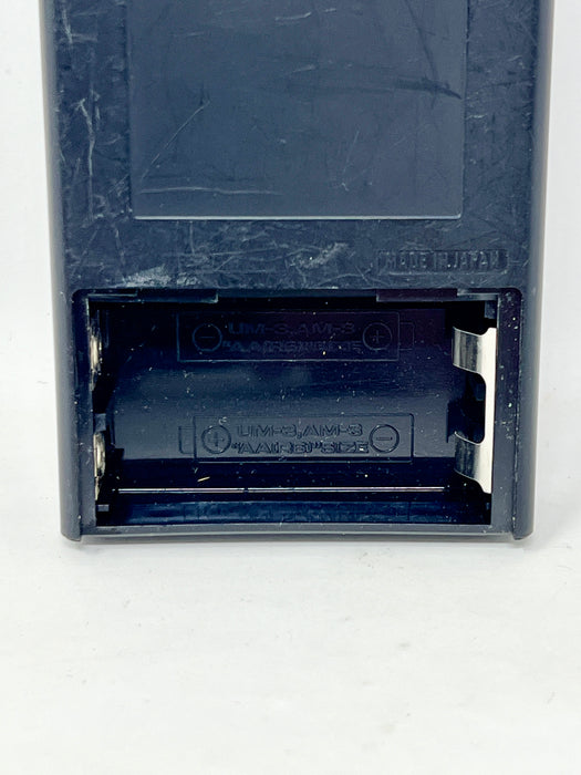 Close-up of the bottom section of a dark blue plastic device showing a battery compartment with a single battery installed and 'MADE IN JAPAN' embossed on the side.