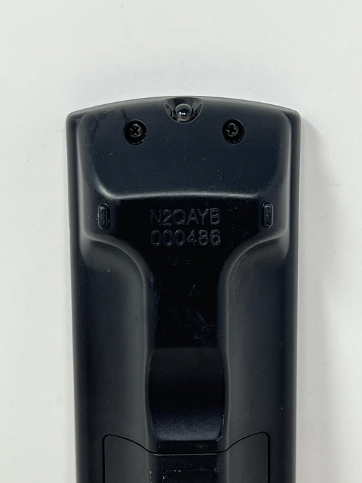 Close-up of the back of a black plastic remote control showing molded serial numbers 'N2QAYB 000486' on a white background.