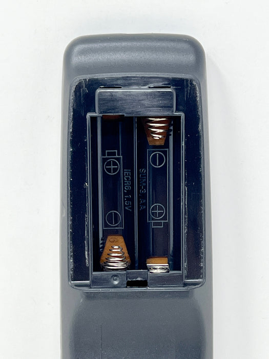 Close-up of a dark gray battery compartment cover with the cover removed, showing two 1.5V batteries installed in a dual-cell battery holder against a plain white background.