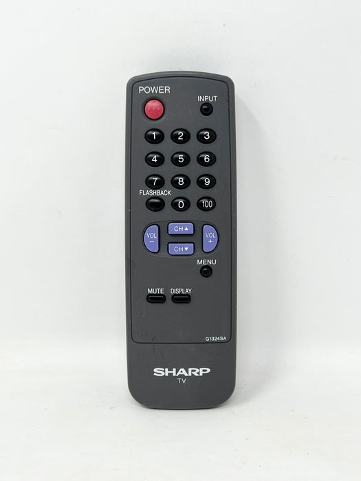 A black Sharp TV remote control with a red power button, blue navigation buttons, and white printed labels on a plain white background.