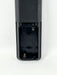 Close-up of the battery compartment of a black remote control, showing two batteries and metal spring contacts on a white background.