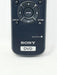 A close-up of a Sony DVD remote control, model RMT-D117A, featuring a dark blue plastic body with white text and a directional pad.