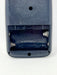 Close-up of the back of a dark blue-gray remote control showing the battery compartment with exposed spring batteries inside.