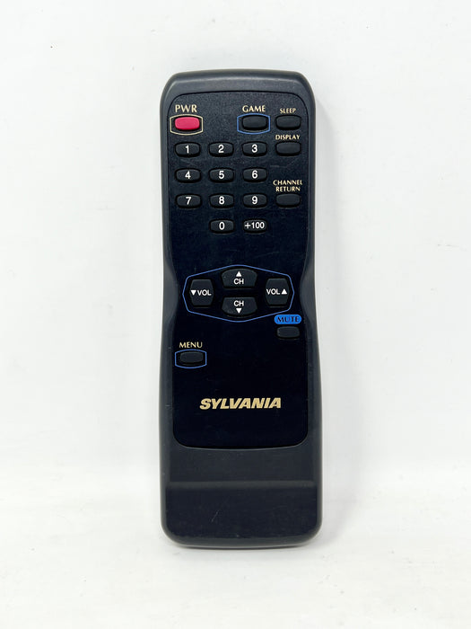 A black Sylvania remote control with gold lettering and blue and red button accents, photographed against a plain white background.